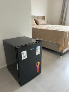 a black refrigerator next to a bed in a room at Villa Marechais in Marechal Deodoro