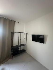 a room with a tv on a white wall at Villa Marechais in Marechal Deodoro
