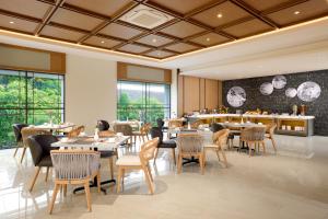 a restaurant with tables and chairs and a bar at Oakwood Yogyakarta in Yogyakarta
