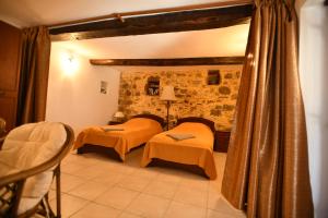 a bedroom with two beds and a stone wall at Rogdia Mountain View Apartment in Rogdhiá