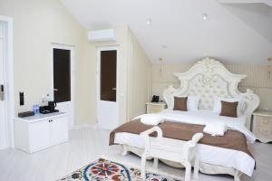 a white bedroom with a large white bed and a bathroom at Veranda XF Hotel in Samarkand +81 photos