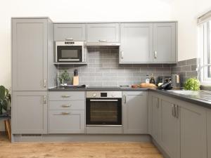 a kitchen with white cabinets and a stove top oven at Little Dunley Cottages - Hazel in Bovey Tracey
