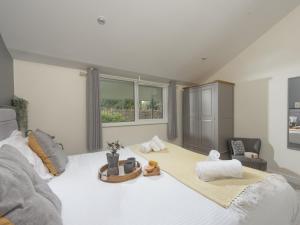 a bedroom with a large white bed with a window at Little Dunley Cottages - Hazel in Bovey Tracey