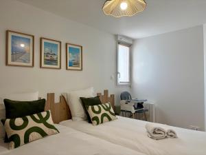 a bedroom with a large bed with green and white pillows at Les Cabines de la Vie in Saint-Gilles-Croix-de-Vie