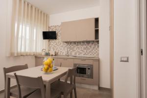 a kitchen with a table with a bowl of fruit on it at Zest House Pompei in Pompei