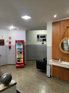 a room with a refridgerator and a chair next to a room with at Carmo Palace Hotel in Carmo do Paranaíba
