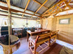 a room with a bench and a table and a chair at Cedar Loft in Las Pilas