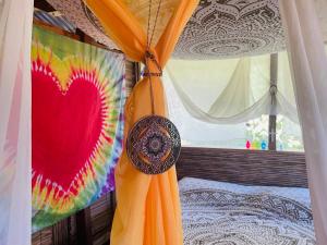 a bed with a curtain with a heart painted on it at Cedar Loft in Las Pilas