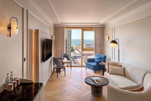 a living room with a couch and chairs and a table at JW Marriott Hotel Kuwait in Kuwait