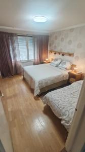 a bedroom with two beds and two lamps in it at Sun in Närpiö