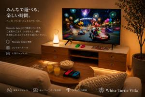 a living room with a flat screen tv and a table at Wight Turtle Villa -Ishigaki Blue Retreat in Ishigaki Island
