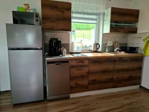 a kitchen with stainless steel appliances and wooden cabinets at Idzikowianka in Idzików