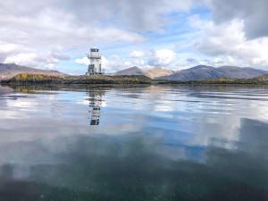 a lighthouse sitting on an island in the water at Creag Bheag in Appin