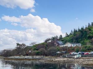 a house on a hill next to a body of water at Creag Bheag in Appin