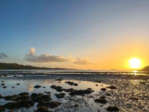 a sunset on a beach with the sun setting at Creag Bheag in Appin +19 photos
