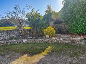 a stone house with a stone wall and trees at Old Chapel Apartment in Kendal
