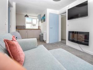 a living room with a couch and a tv at Old Chapel Apartment in Kendal