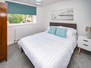 a bedroom with a large white bed with blue pillows at Old Chapel Apartment in Kendal +5 photos