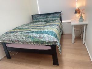 a bed in a room with a table and a bedspread at Private Rm6in Elderslie in Elderslie