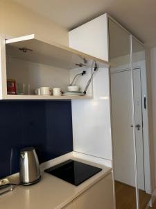 a kitchen with white cabinets and a counter top at Orbi in Batumi 24 in Angisa +32 photos