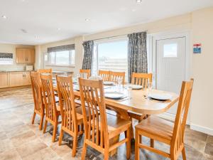 a kitchen and dining room with a wooden table and chairs at Meadow Lakes in St Austell
