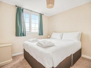 a bedroom with a large white bed with a window at Meadow Lakes in St Austell