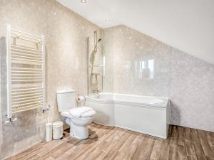 a bathroom with a toilet and a tub and a sink at Meadow Lakes in St Austell +24 photos