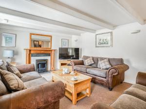 a living room with two couches and a coffee table at Meadow Lakes in St Austell