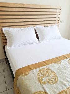 a large bed with white sheets and pillows at Madibak Hotel Limbe in Limbe +36 photos