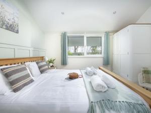 a bedroom with a large bed with towels on it at Little Dunley Cottages - Willow in Bovey Tracey