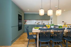 a kitchen with a wooden table and blue cabinets at The Moorings in St Ives