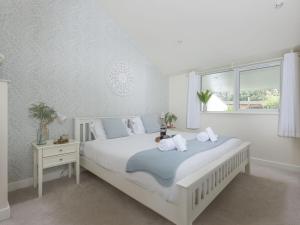 a white bedroom with a white bed and a window at Little Dunley Cottages - Maple in Bovey Tracey