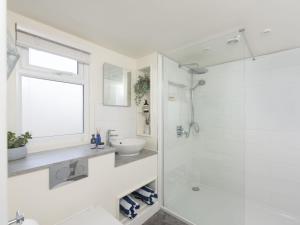 a white bathroom with a shower and a sink at Little Dunley Cottages - Maple in Bovey Tracey +3 photos
