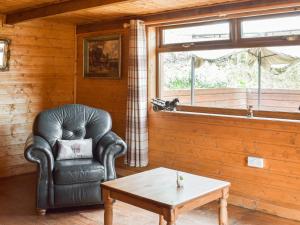 a living room with a leather chair and a coffee table at Cow Boy Cabin - Uk47145 in Glasgow