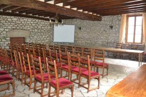 a room with a row of wooden chairs and a whiteboard at Logis hotel Saint-Joseph in Sancoins