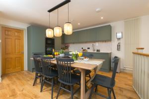 a kitchen and dining room with a wooden table and chairs at The Moorings in St Ives +8 photos