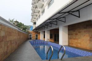 an external view of a building with a swimming pool at Zam Hotel By Pavotel in Kedungbadak