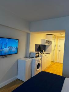 a room with a washing machine and a tv at Orbi in Batumi 24 in Angisa