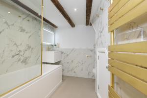a bathroom with white marble walls and a shower at The Moorings in St Ives