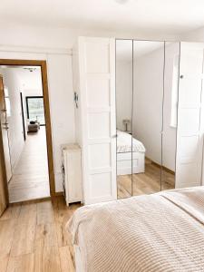 a white bedroom with a bed and a mirror at Apartment ALBA in Medulin