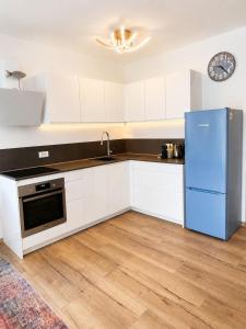 a kitchen with white cabinets and a blue refrigerator at Apartment ALBA in Medulin