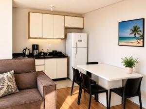 a kitchen and living room with a table and a couch at Bocaiuva 139 - BeXap Stays in Chapecó
