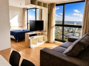 a living room with a couch and a bed and a large window at Bocaiuva 139 - BeXap Stays in Chapecó