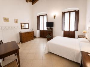 a bedroom with a bed and a desk and a tv at L'Antica Torre Caralis Holiday in Cagliari