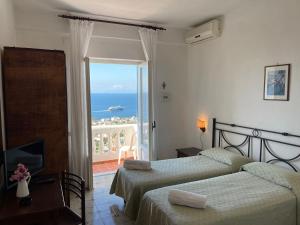 a bedroom with two beds and a view of the ocean at Hotel Residence - Parco Mare Monte in Casamicciola Terme