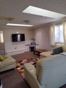 a living room with two couches and a flat screen tv at lockwood house holiday cottages,Dawlish in Starcross