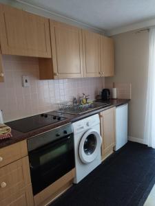 a kitchen with a washer and a dishwasher at lockwood house holiday cottages,Dawlish in Starcross