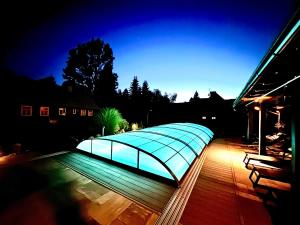 a large glass pavilion on a deck at night at Chalet Schäfer s vyhřívaným bazénem se slanou vodou a saunou in Harrachov +111 photos