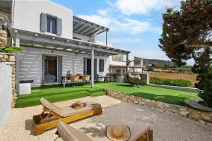 a backyard with a lawn and a house at Juniper View in Aspro Chorio Paros