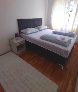 a bedroom with a large bed with a window at Apartman Natasha in Trebinje